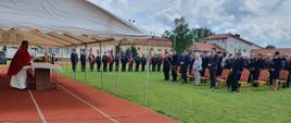 Zdjęcie przedstawia gości biorących udział we mszy świętej prowadzonej przez księdza kapelana na placu przed budynkiem OSP w Dąbrówce