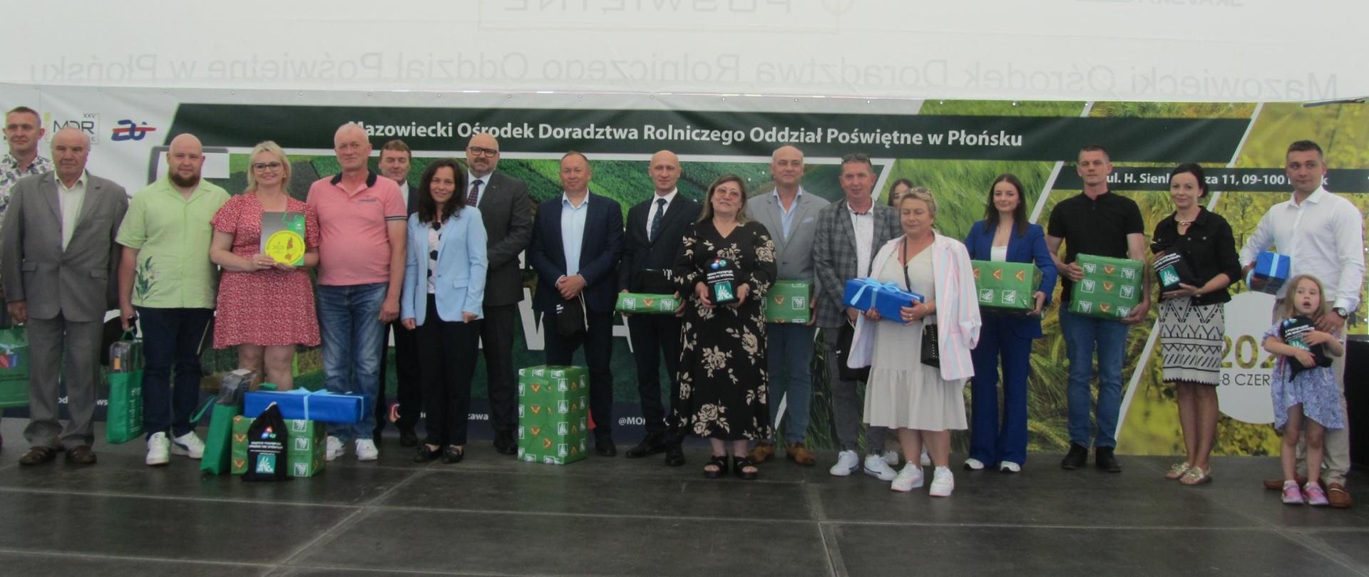Na scenie właściciele wszystkich nagrodzonych gospodarstw pozują do zdjęć z otrzymanymi nagrodami w towarzystwie przedstawicieli organizatorów oraz sponsorów regionalnego etapu konkursu.