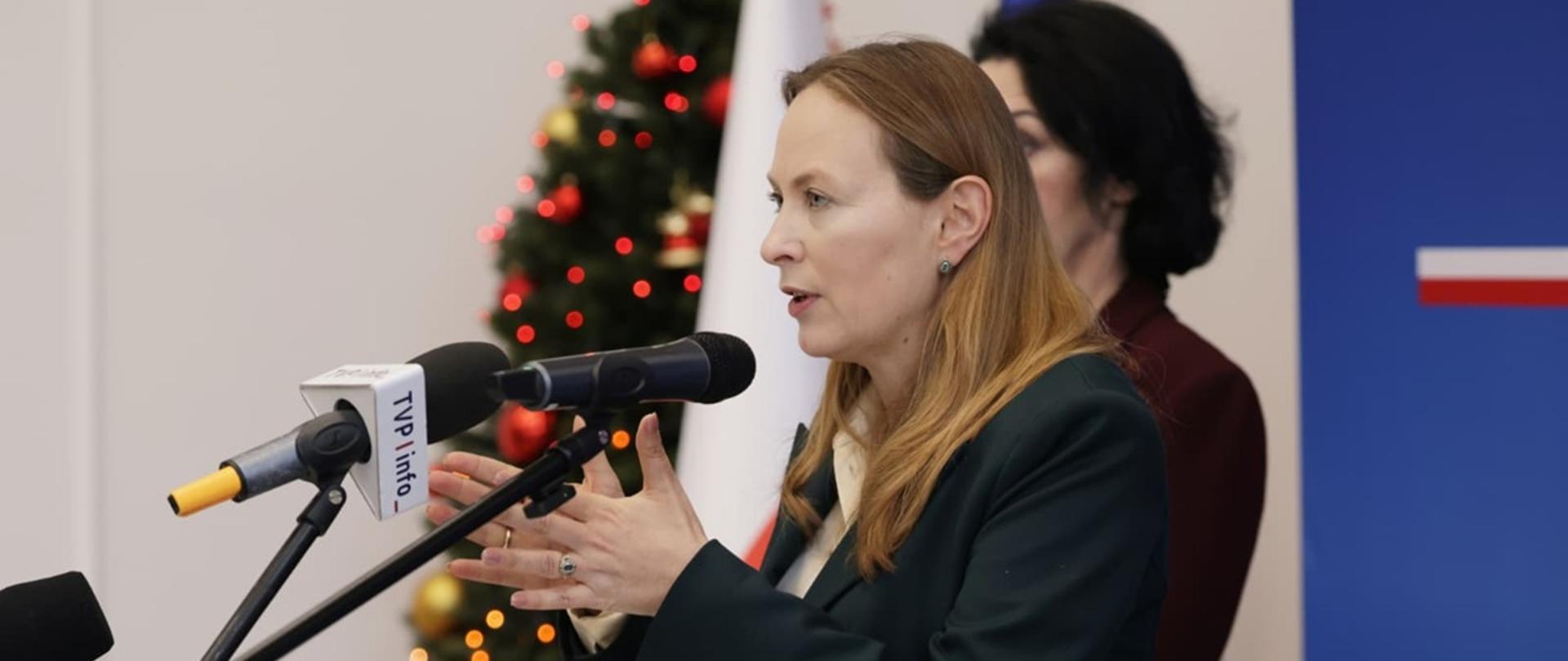 Na zdjęciu minister Katarzyna Pełczyńska-Nałęcz przed mikrofonami odpowiada na pytania dziennikarzy