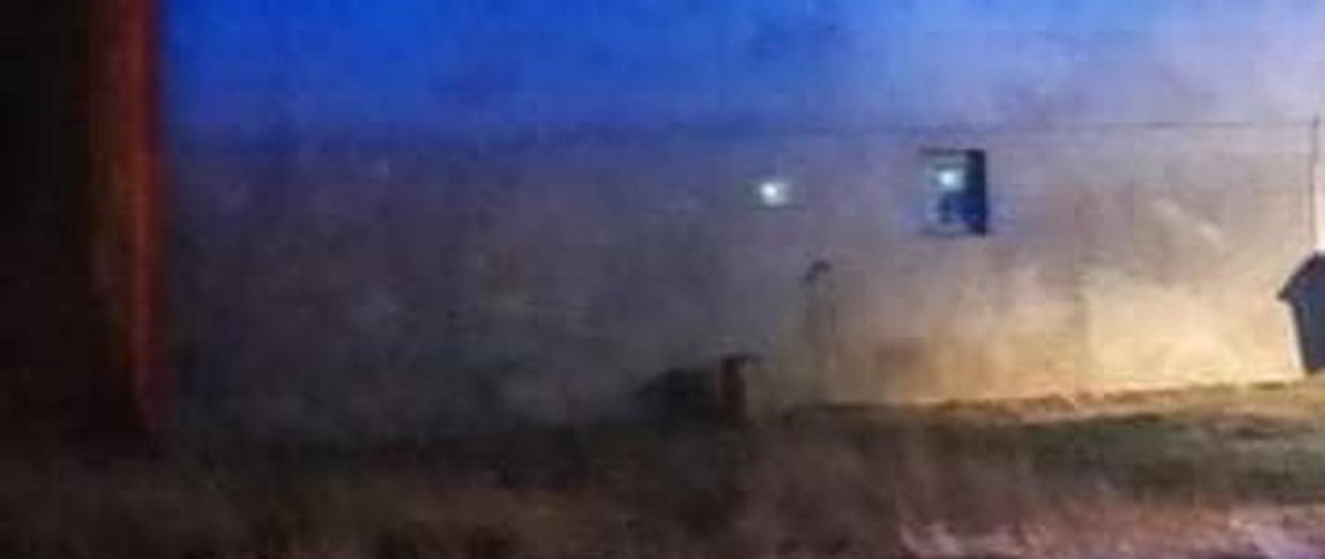 Samochód ratowniczo gaśniczy stojący przy budynku, w którym doszło do zapalenia się sadzy w kominie.