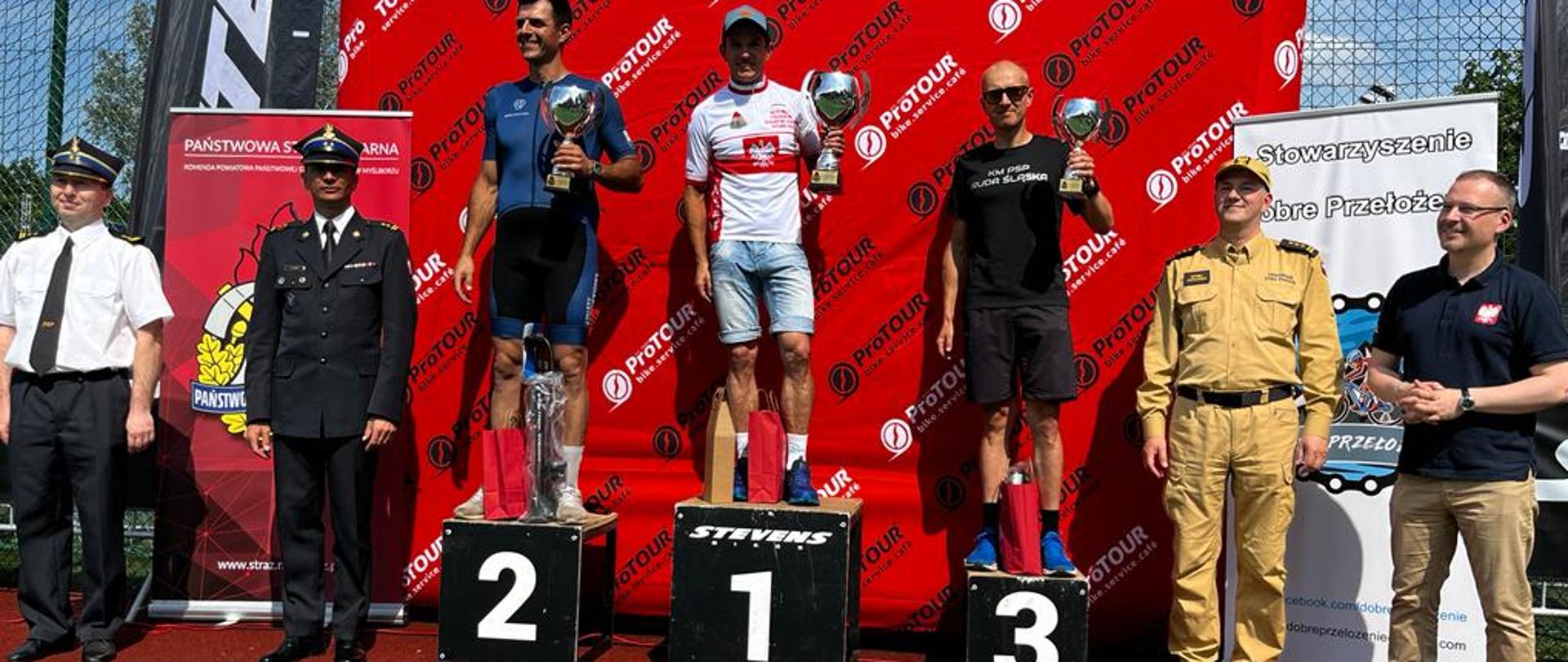 Zdjęcie przedstawia funkcjonariuszy PSP, którzy zdobyli 3 najlepsze miejsca podczas Mistrzostw Polski Strażaków PSP w kolarstwie szosowym.