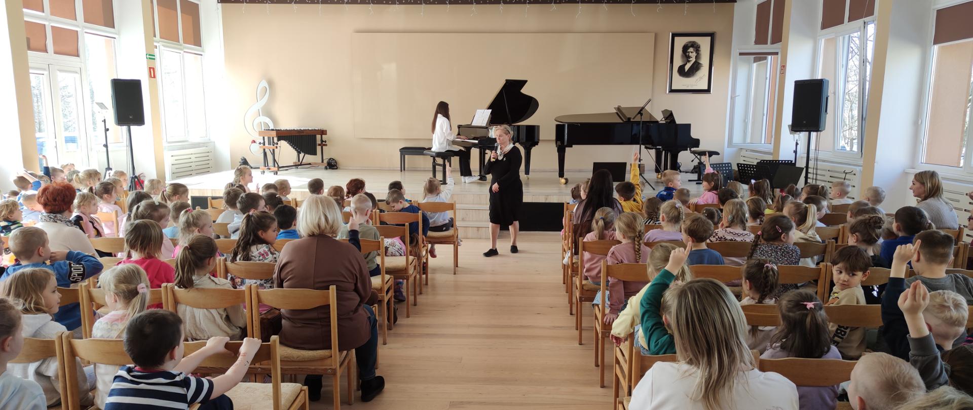 dzieci siedzące na widowni