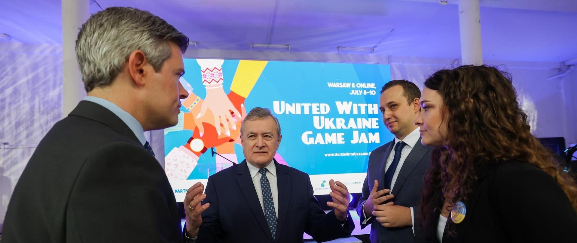 PiotrGlinski, Justyna Orłowska, Erik Catalfamo i MikołajTurowski na tle United with Ukraine Game Jam.