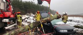 Strażacy wykonują stabilizacje rozbitego pojazdu.