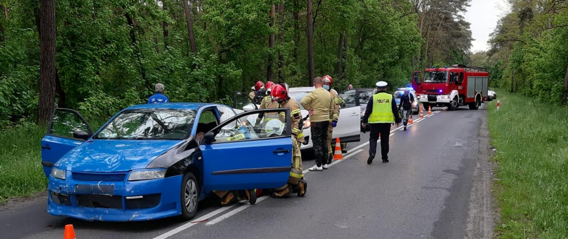 Na zdjęciu rozbite samochody, strażacy policja oraz samochód ratowniczo - gaśniczy