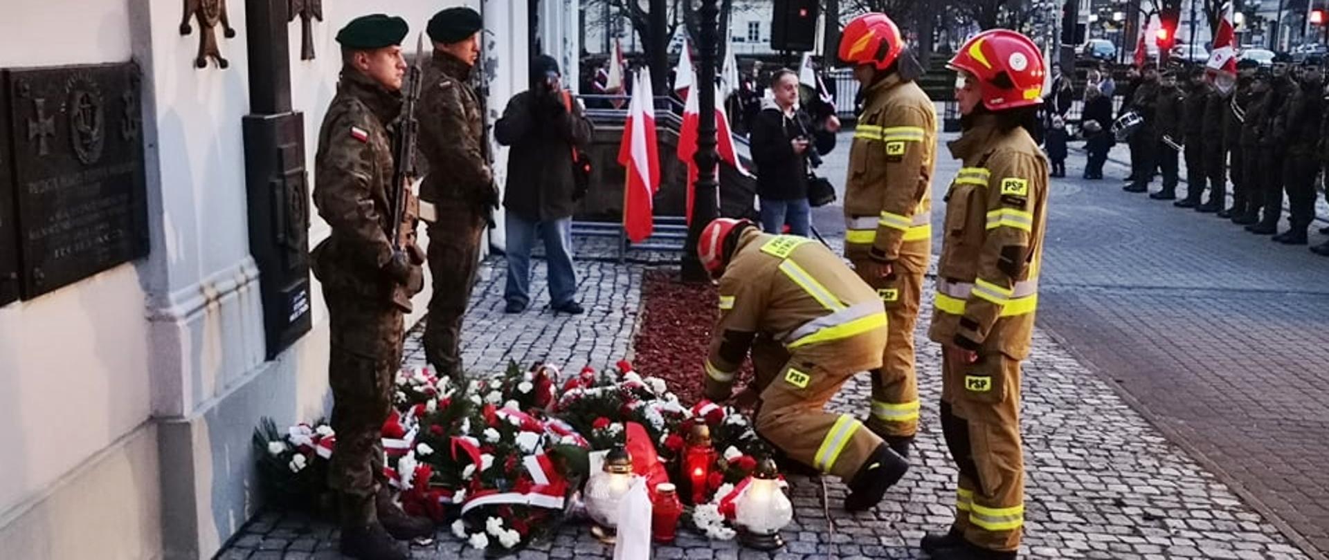 Obchody 82. rocznicy Zbrodni Katyńskiej - trzech strażaków Komendy Miejskiej PSP w Siedlcach, składając znicz pod Tablicą Katyńską.
