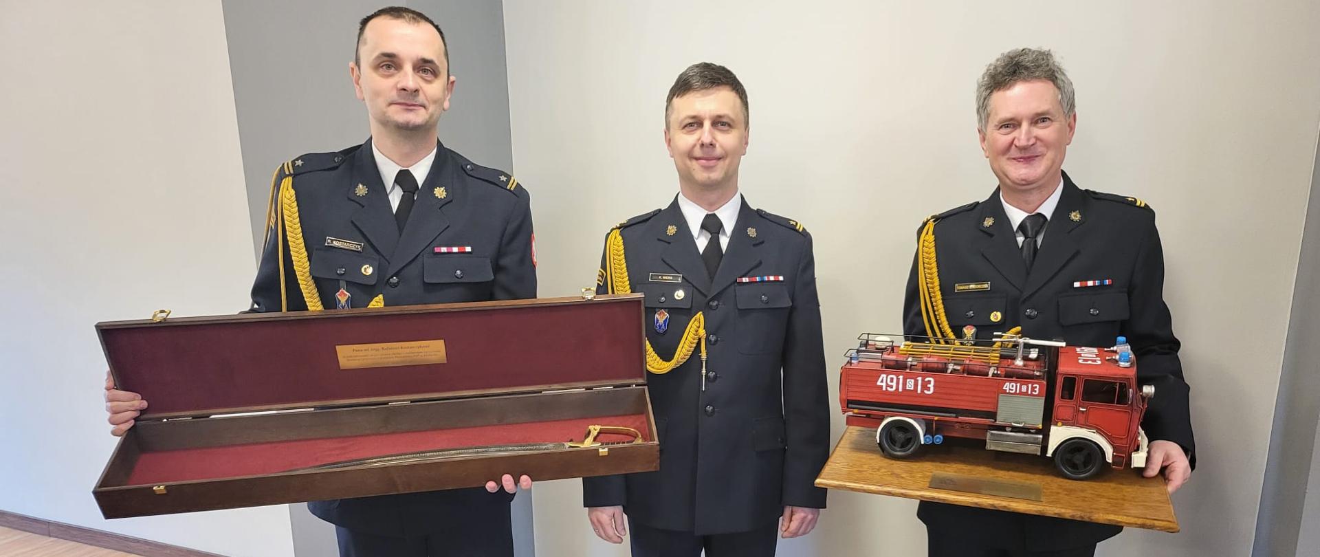 Zdjęcie przedstawia uroczystą zbiórkę, z okazji zakończenia czynnej służby w Państwowej Straży Pożarnej mł. bryg. Rafała Kostarczyka - Zastępcy Komendanta Powiatowego PSP w Kłobucku oraz mł. bryg. Tomasza Izydorczyka – dowódcy zmiany