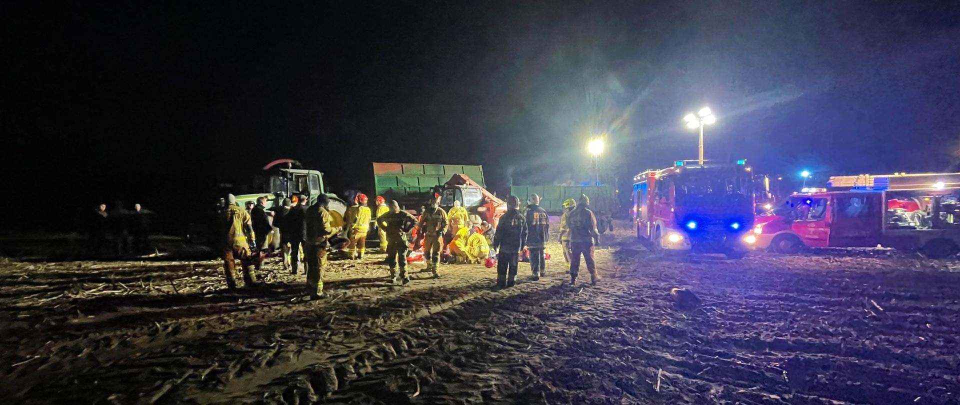 na zdjęciu służby na polu podczas wypadku, samochody straży pożarnej, policji i pogotowia