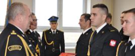 Na zdjęciu Komendant Powiatowy PSP w Rypinie st. bryg. mgr inż. Grzegorz Łydkowski wręcza strażakom awanse.
