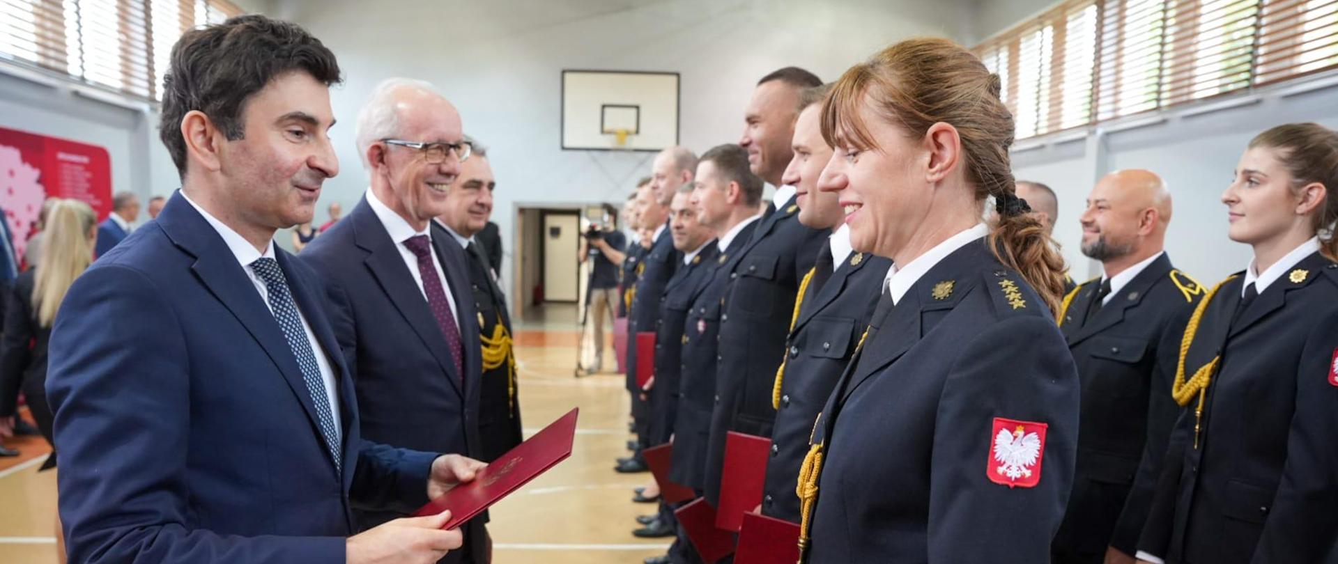 Wojewoda wraz z wiceministrem SWiA oraz zastępcą komendanta głównego PSP wręczają listy pochwalne strażakom
