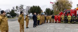 Na zdjęciu widać strażaków Państwowej i Ochotniczej Straży Pożarnej, kierownictwo zakładu oraz zakładowej służby ratownictwa chemicznego ZAK SA. W tle widać samochody strażackie oraz szyld Grupy Azoty.