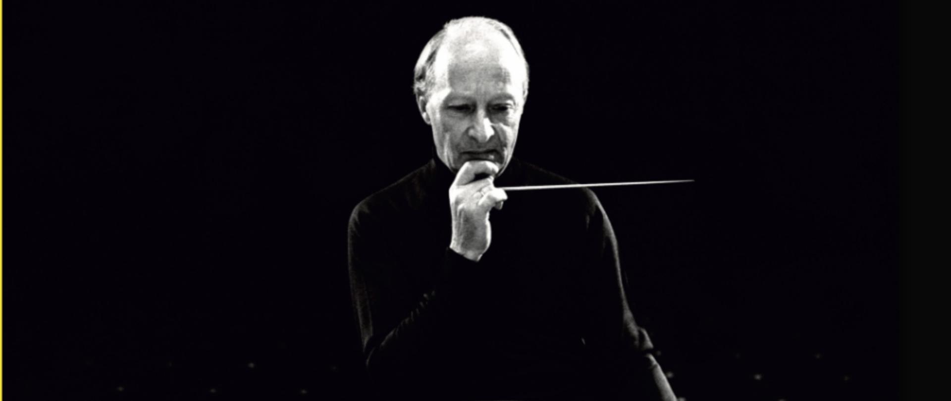 Zdjęcie przedstawia Witolda Lutosławskiego przy pulpicie dyrygenckim.