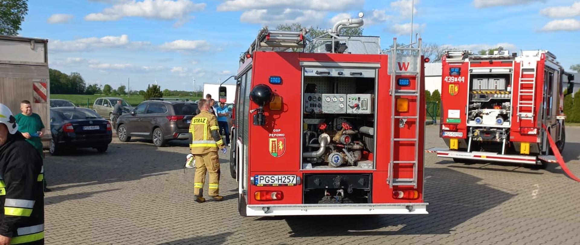 Zdjęcie przedstawia pojazdy pożarnicze stojące na placu firmy. 