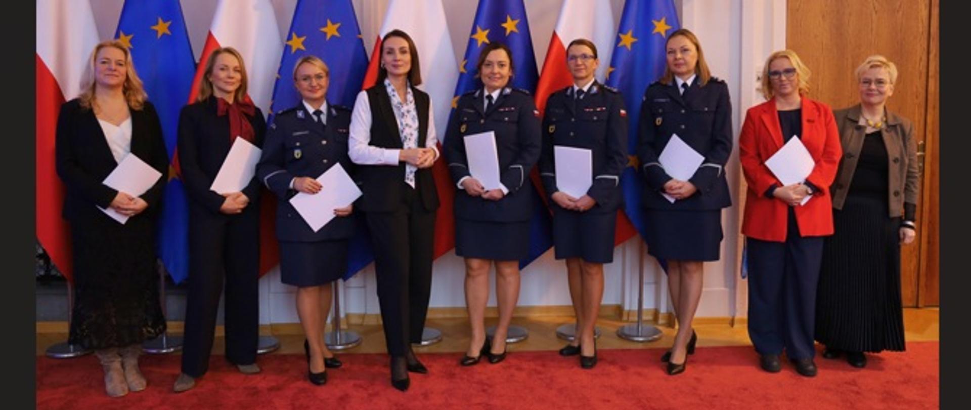 kilka kobiet stoi w sali i pozuje do zdjęcia na tle flag polskiej i unijnej