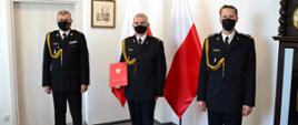 Zdjęcie przedstawia pomorskiego komendanta wojewódzkiego PSP st. bryg. Piotra Sochę, komendanta powiatowego PSP w Człuchowie st. bryg. Ernesta Szczepańskiego oraz p.o. zastępcy komendanta powiatowego PSP w Człuchowie bryg. Radosława Batrucha po wręczeniu decyzji.