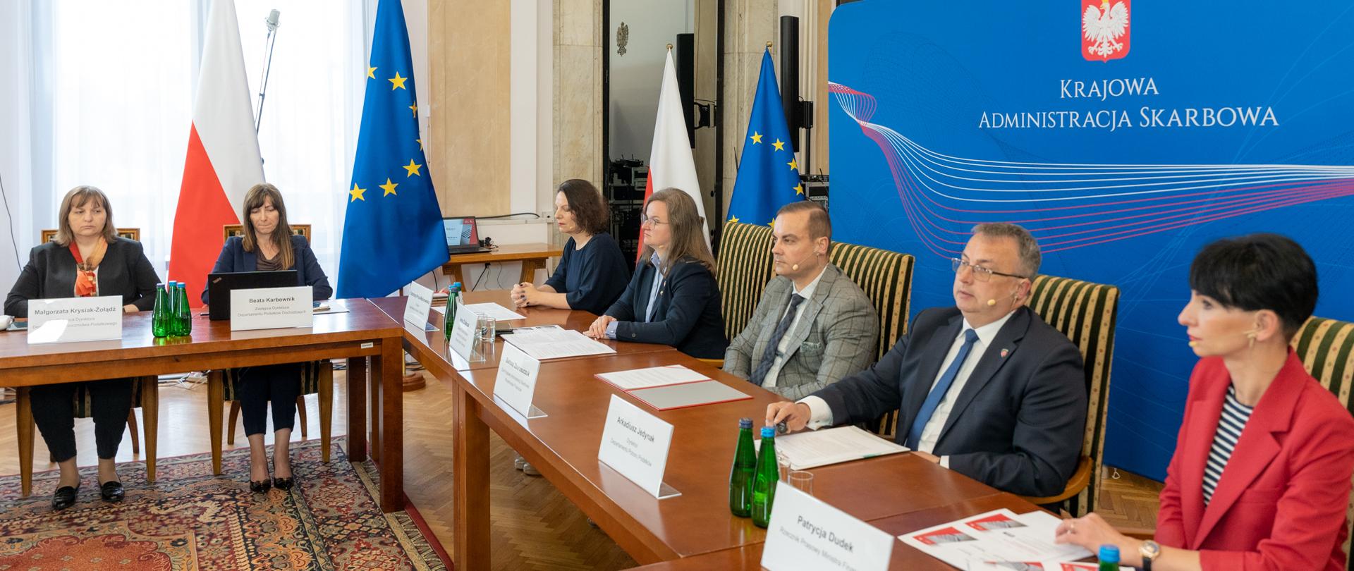 Uczestnicy spotkania, w tle ścianka z napisem Krajowa Administracja Skarbowa.