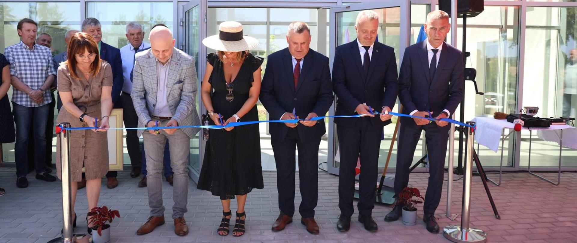 
Grupa ludzi stojąca przed budynkiem
