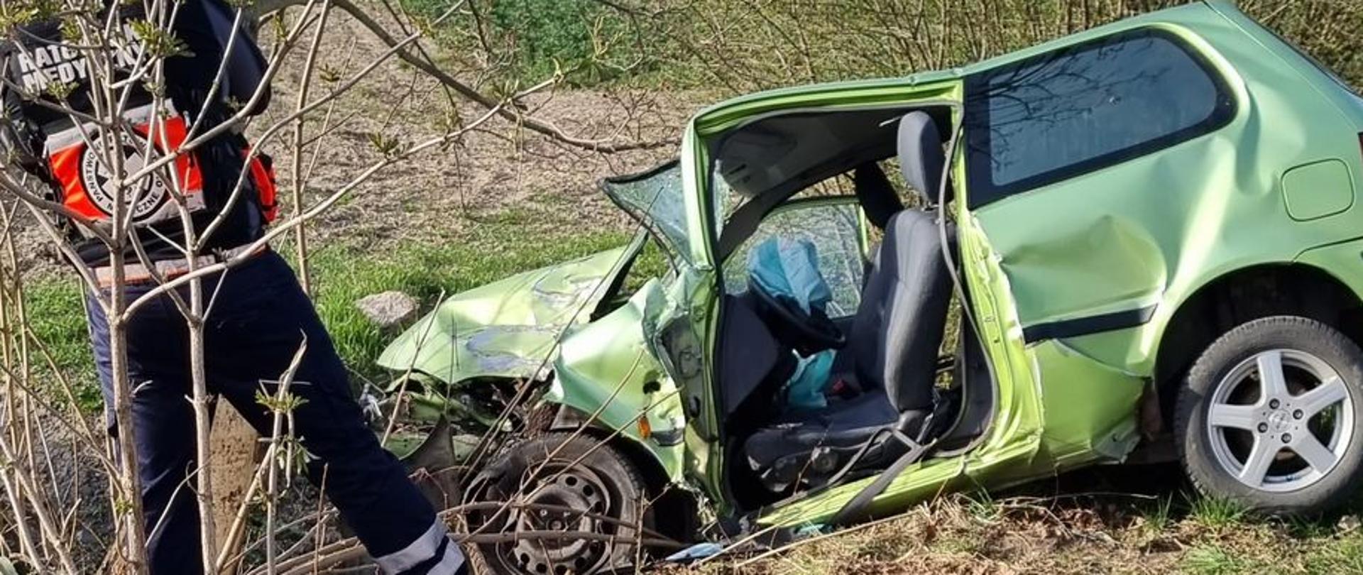 pora dzienna. Kadr przedstawia zniszczony po uderzeniu czołowym pojazd koloru jasnozielonego.
