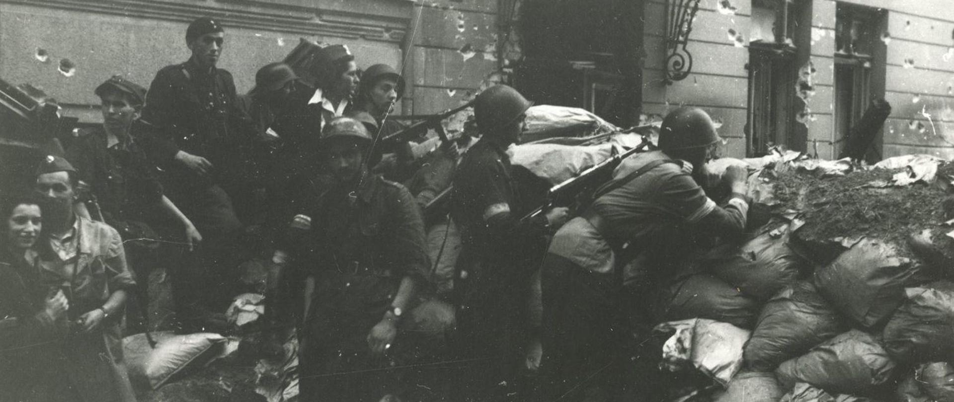 Grupa powstańców warszawskich na barykadzie.