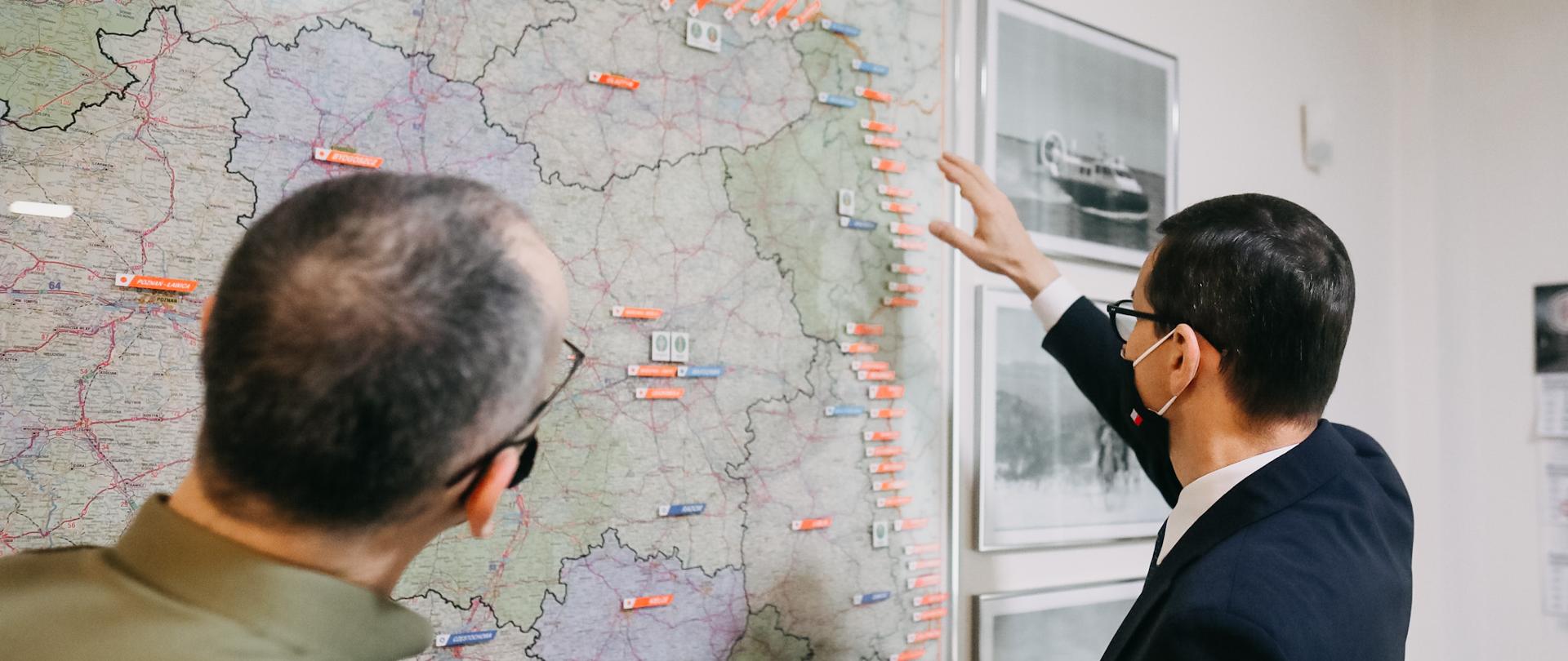 Premier, komendant Straży Granicznej stoją przy mapie Polski.
