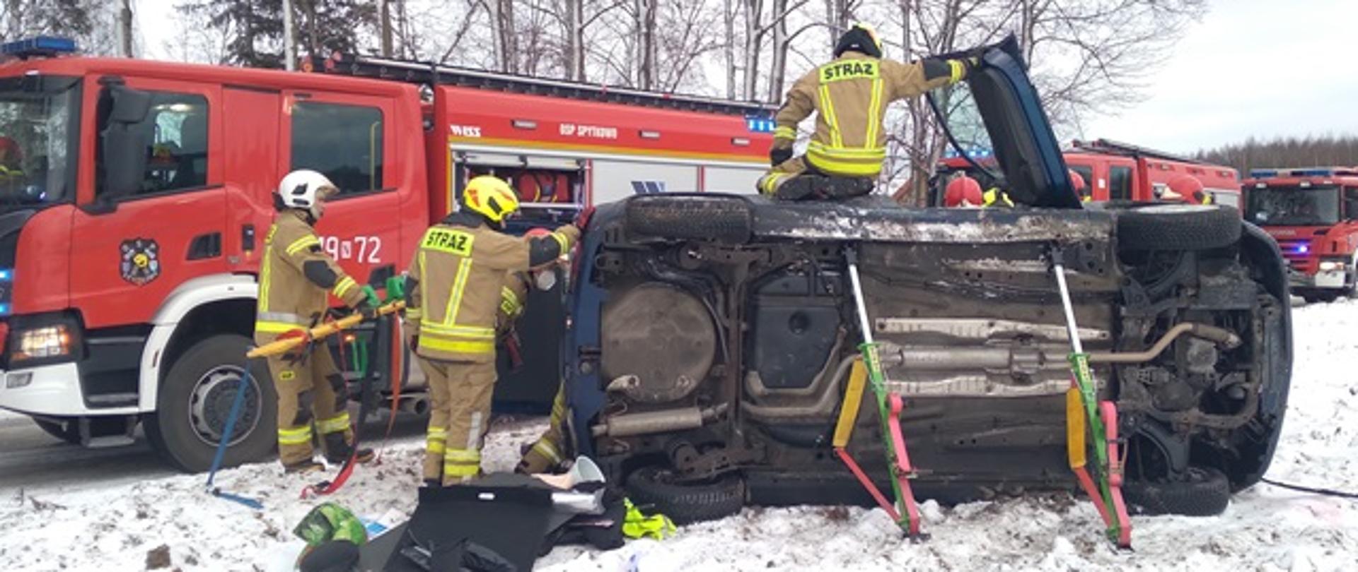 Strażacy udzielają pomocy poszkodowanemu w wypadku