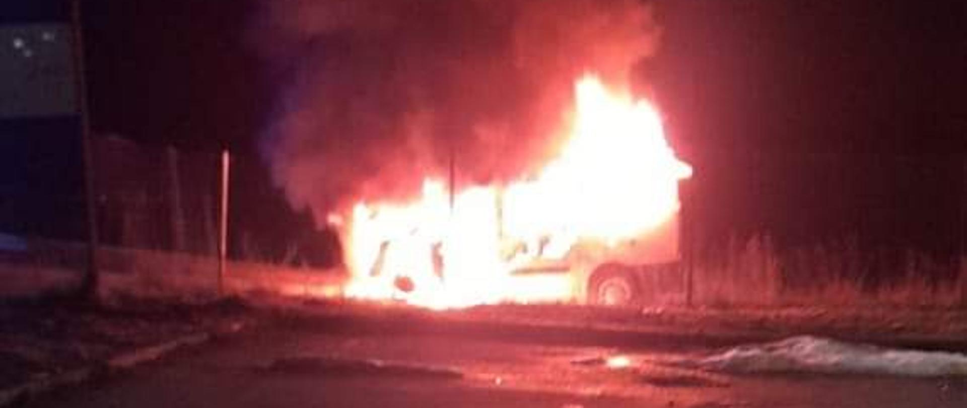Zdjęcie obrazuje palący się samochód w nocy.