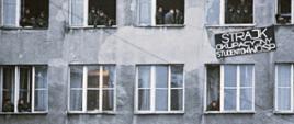 okna uczelni, studenci i transparent informujący o strajku