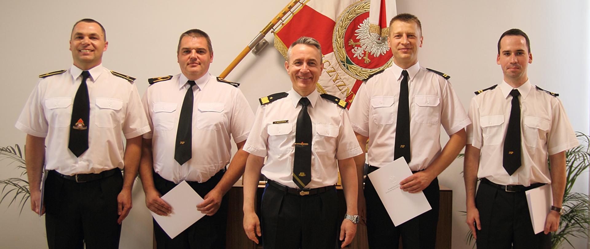 Nagrody za walkę z koronawirusem – na zdjęciu czterech nagrodzonych strażaków. Po środku komendanta główny PSP nadbryg. Andrzej Bartkowiak.