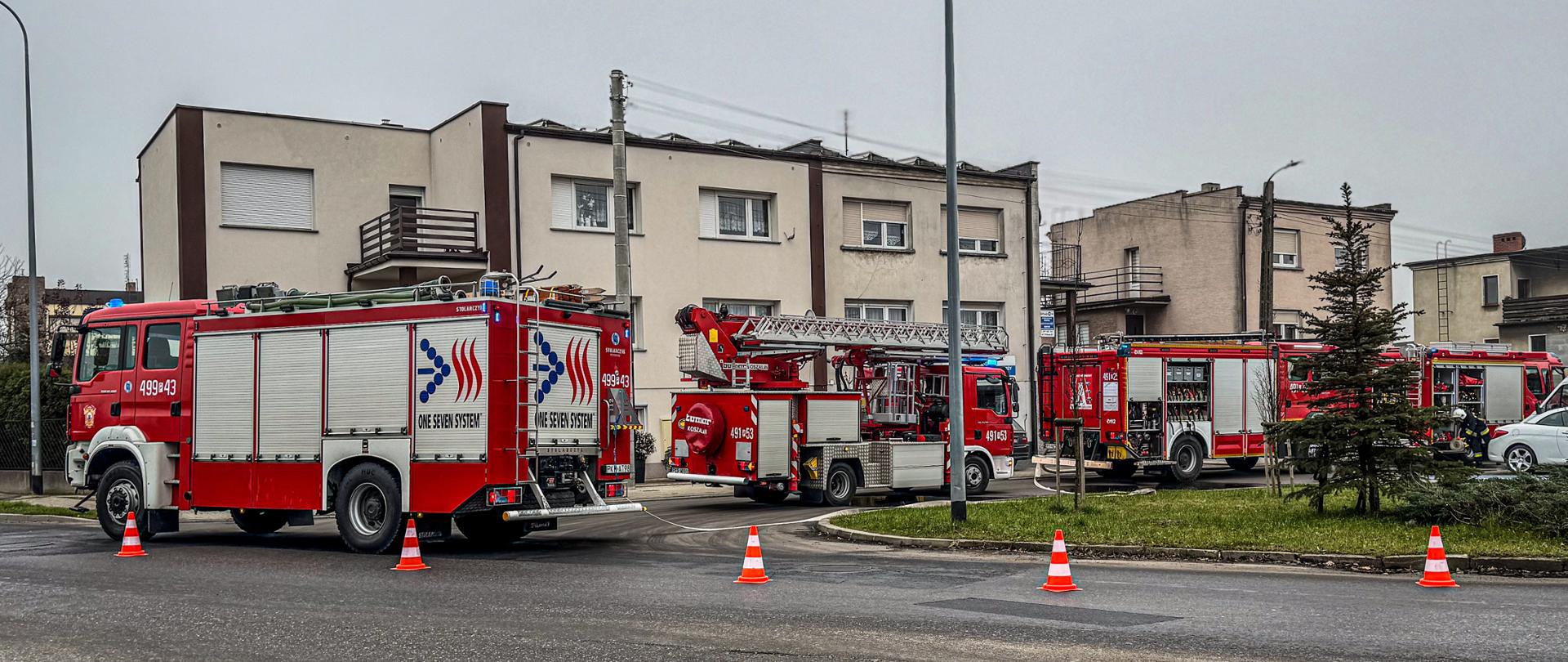 Zdjęcie przedstawia ustawienie pojazdów straży pożarnej podczas prowadzonych działań ratowniczo-gaśniczych.