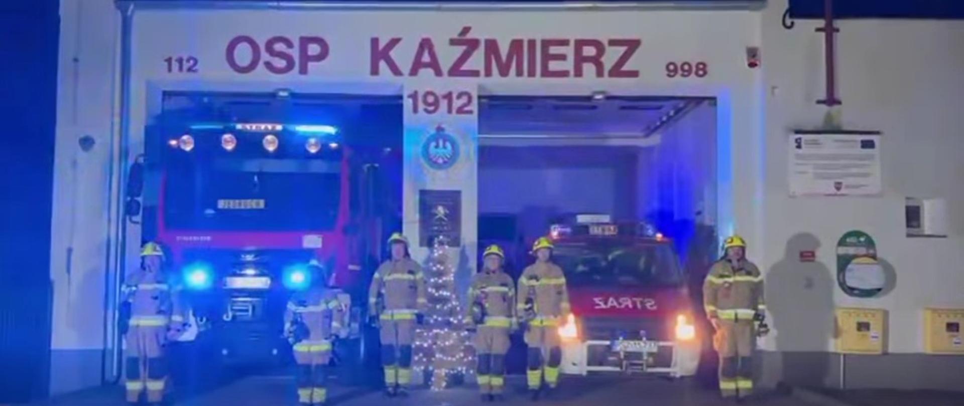 Strażacy przed budynkiem straży, jest ciemno