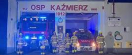 Strażacy przed budynkiem straży, jest ciemno