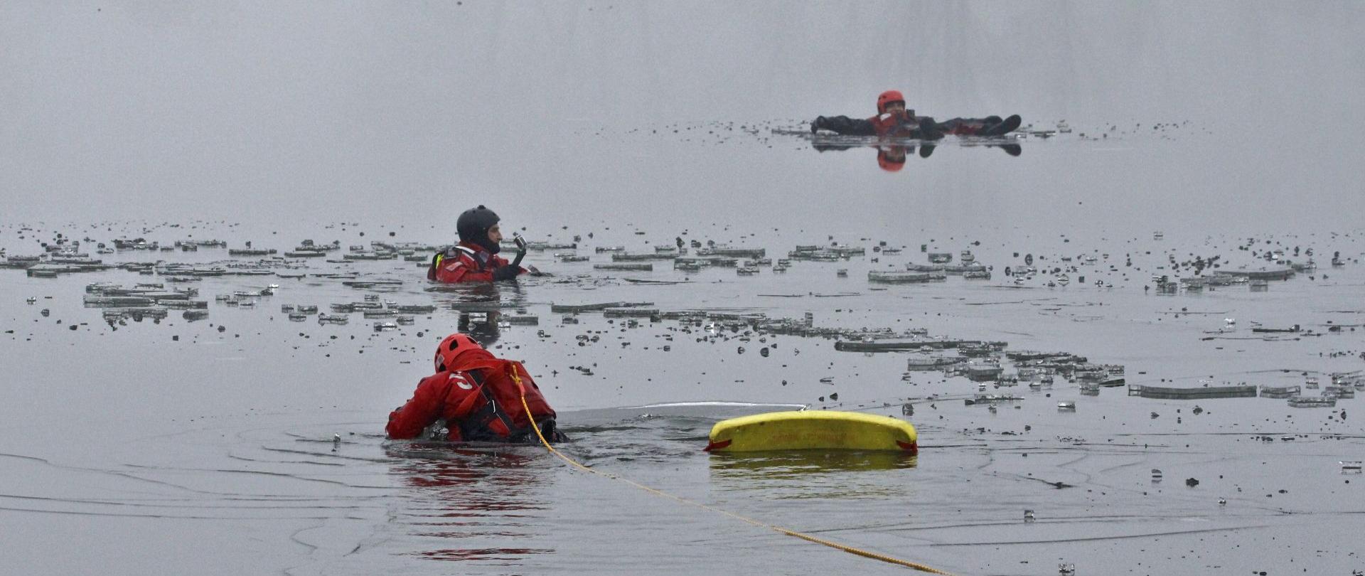 Ratownicy w akwenie wodnym ćwiczą podejmowanie osób z wody