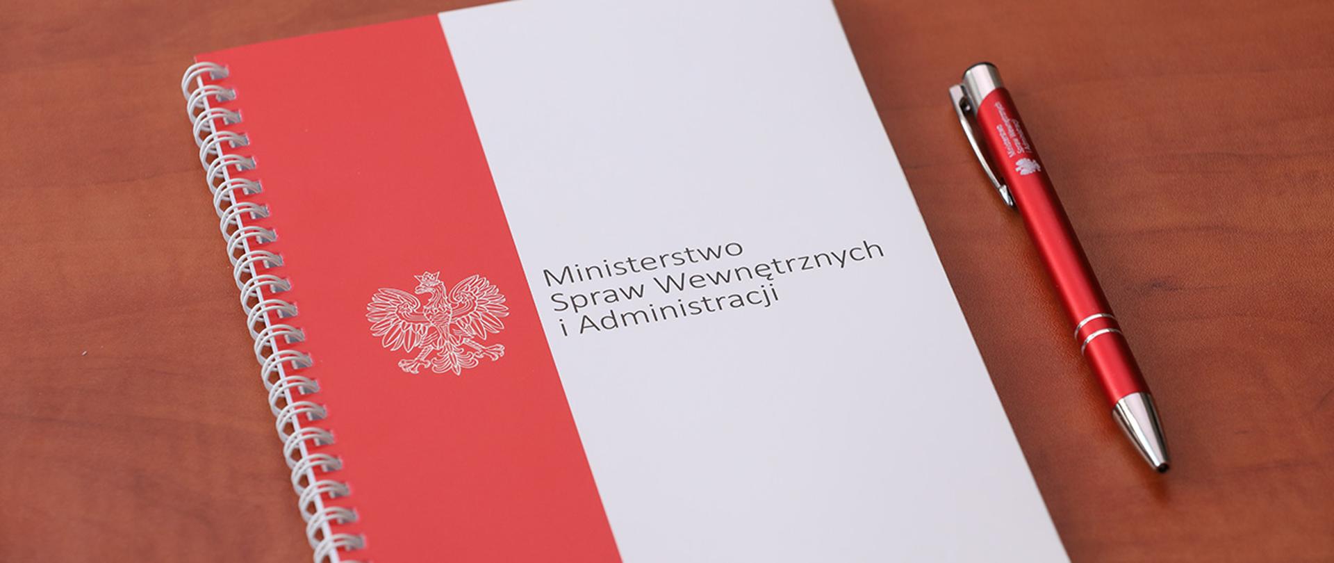Notes MSWiA, obok długopis z logo resortu