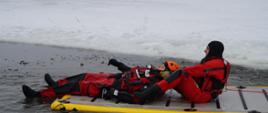 strażak znajdujący się na trapie powietrznym wyciąga osobę pod którą załamał się lód