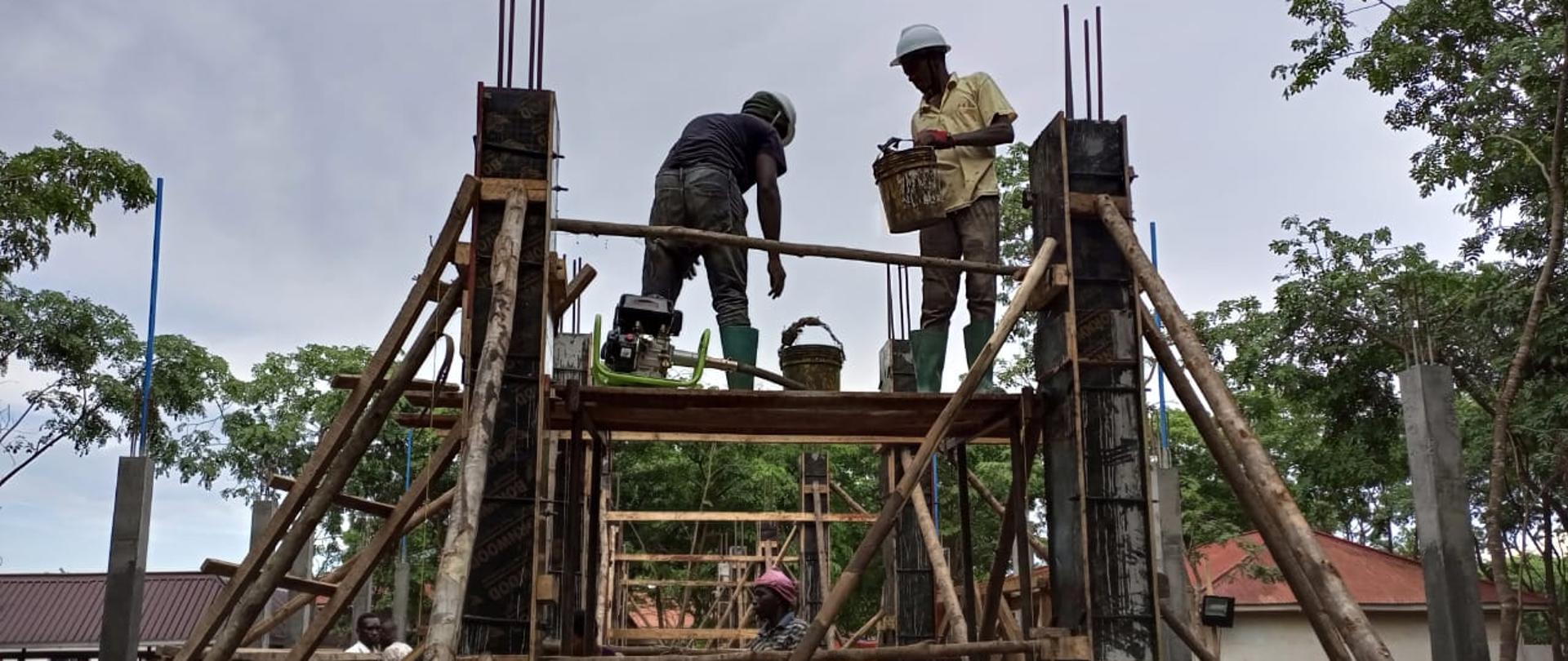 Rusztowanie budowlane, na nim pracownicy.