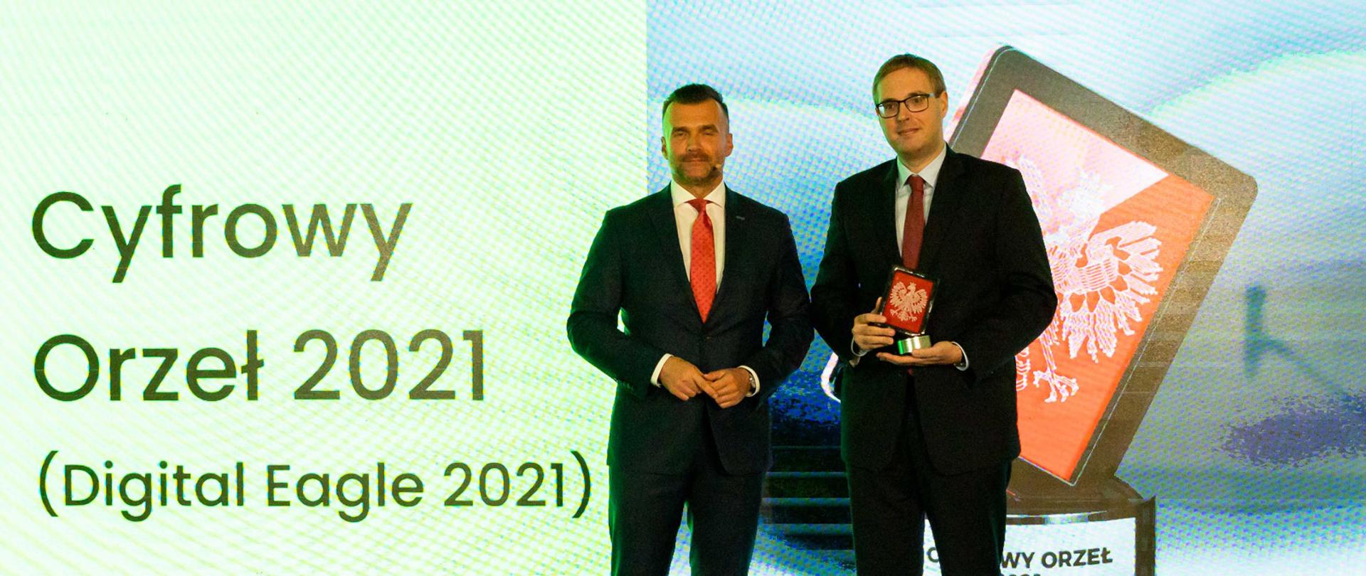 Na scenie wiceminister Jan Sarnowski ze statuetką, obok niego stoi prezes Związku Cyfrowa Polska Michał Kanownik.