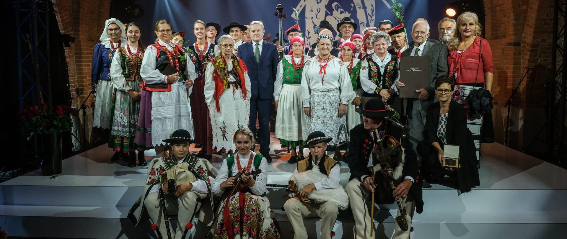 grupa ludzi w kolorowych strojach ludowych pozuje do zdjęcia