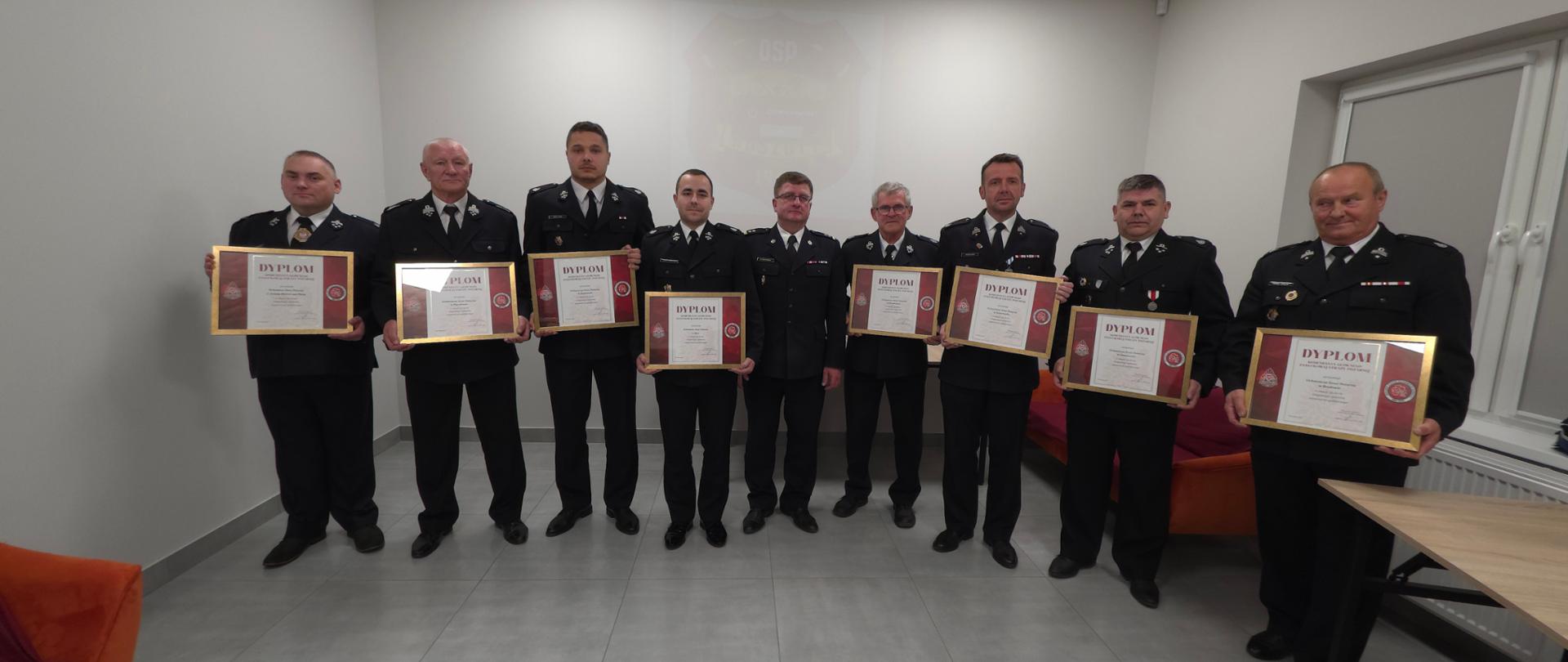 Strażacy OSP w mundurach odbierają dyplom kg psp z rąk komendanta powiatowego psp