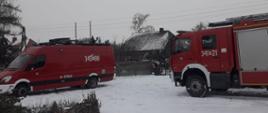 Zdjęcie przedstawia samochód dowodzenia i łączności oraz wóz strażacki biorący udział w akcji poszukiwawczej. Z lewej strony zdjęcia widzimy czerwony wóz dowodzenia i łączności koloru czerwonego oznakowany napisem operacyjnym koloru białego trzysta czterdzieści P dziewięćdziesiąt osiem. Na dachu wozu zestaw anten nadawczo - odbiorczych oraz niebieskie sygnały ostrzegawcze. Z prawej strony kadru widzimy część wozu strażacki koloru czerwonego, białe nadkola, w tylnej części srebrne żaluzje, na dachu srebrna drabina. Samochód oznakowany białym numerem operacyjnym trzysta czterdzieści jeden P dwadzieścia jeden. Dalej za pojazdami widzimy zabudowania jednorodzinne oraz krzaki i drzewa. Aura zimowa, na ziemi wyjeżdżony śnieg. Niebo zachmurzone.