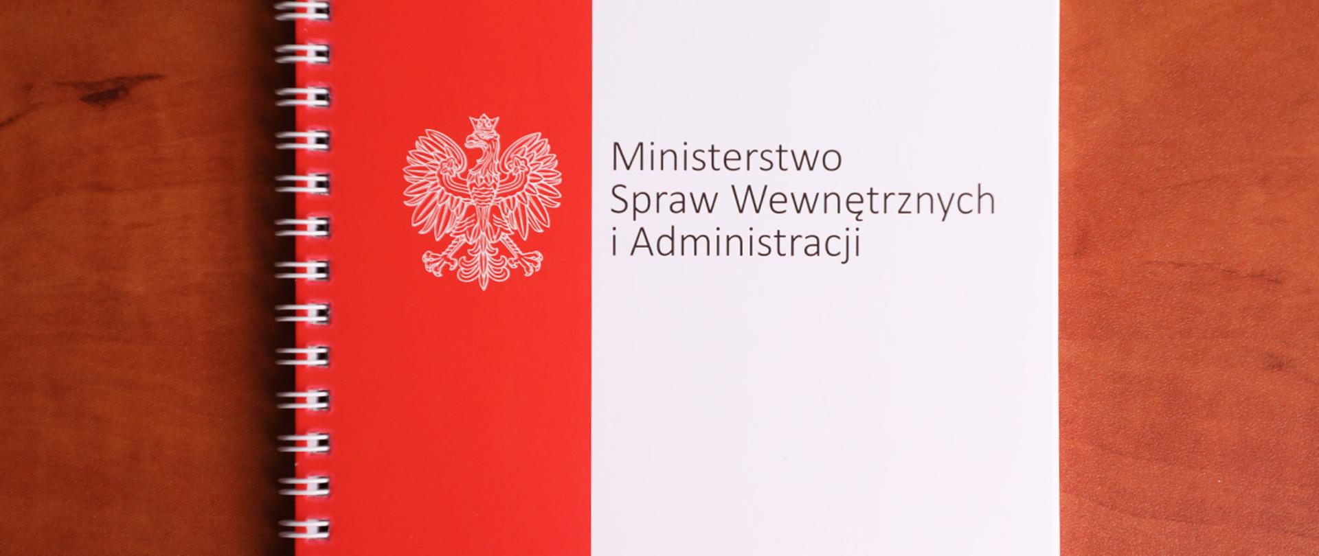 Notes MSWiA leżący na drewnianej powierzchni 