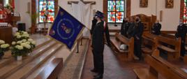 Poczet sztandarowy salutuje na przywitanie przed ołtarzem. 