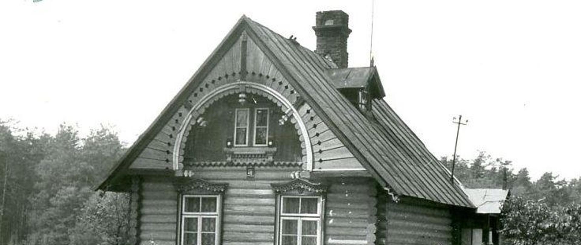 Drewniany, parterowy domek z dachem dwuspadowym, kryty blachą. Po prawej stronie dachu niewielka lukarna. Od strony ulicy okrągły, drewniany, ozdobny fronton z oknem. Wokół domku ogródek ogrodzony siatka.