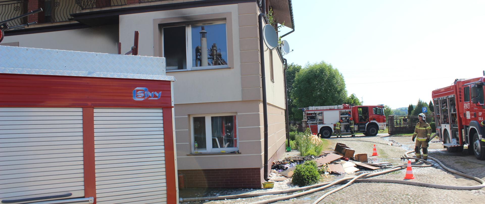 Pożar budynku mieszkalnego w Koszelach - samochody ratowniczo-gaśnicze stojące wokół budynku, w którym miał miejsce pożar.