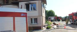 Pożar budynku mieszkalnego w Koszelach - samochody ratowniczo-gaśnicze stojące wokół budynku, w którym miał miejsce pożar.