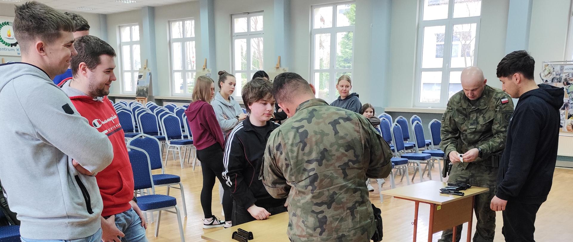 Na zdjęciu widoczny instruktor (zawodowy wojskowy) pokazujący uczniom obsługę boni.