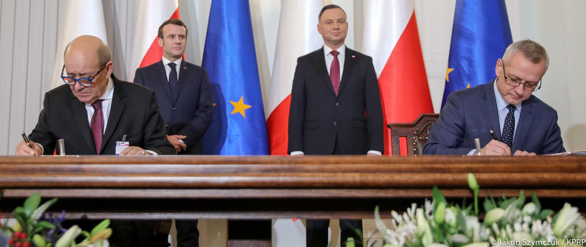 The moment of signing the declaration - at the table (on the left) the Minister of Europe and Foreign Affairs of France Jean-Yves Le Drian, (on the right) Minister of Digital Affairs Marek Zagórski. Behind them are: (on the left) President of France Emmanuel Macron, (on the right) President of the Republic of Poland Andrzej Duda