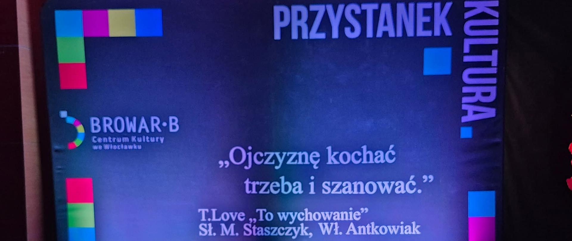 Zdjęcie przedstawia podświetlane stoisko wystawowe, prawdopodobnie na wydarzeniu kulturalnym. Dominują kolory ciemnoniebieski i czarny. Po lewej stronie i na górze znajdują się kolorowe paski w odcieniach różowego, niebieskiego, żółtego i zielonego.
W lewym górnym rogu znajduje się logo z napisem BROWAR·B oraz pod nim mniejszy tekst: Centrum Kultury we Włocławku.
W prawym górnym rogu, pionowo, widnieje napis KULTURA, a poziomo obok niego PRZYSTANEK.
Centralna część stoiska zawiera duży, biały cytat: „Ojczyznę kochać trzeba i szanować.”. Poniżej, mniejszą czcionką, podano źródło cytatu: T.Love „To wychowanie” Sł. M. Staszczyk, Wł. Antkowiak.