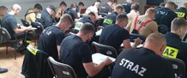 Zdjęcie przedstawia strażaków ochotników podczas egzaminu teoretycznego.