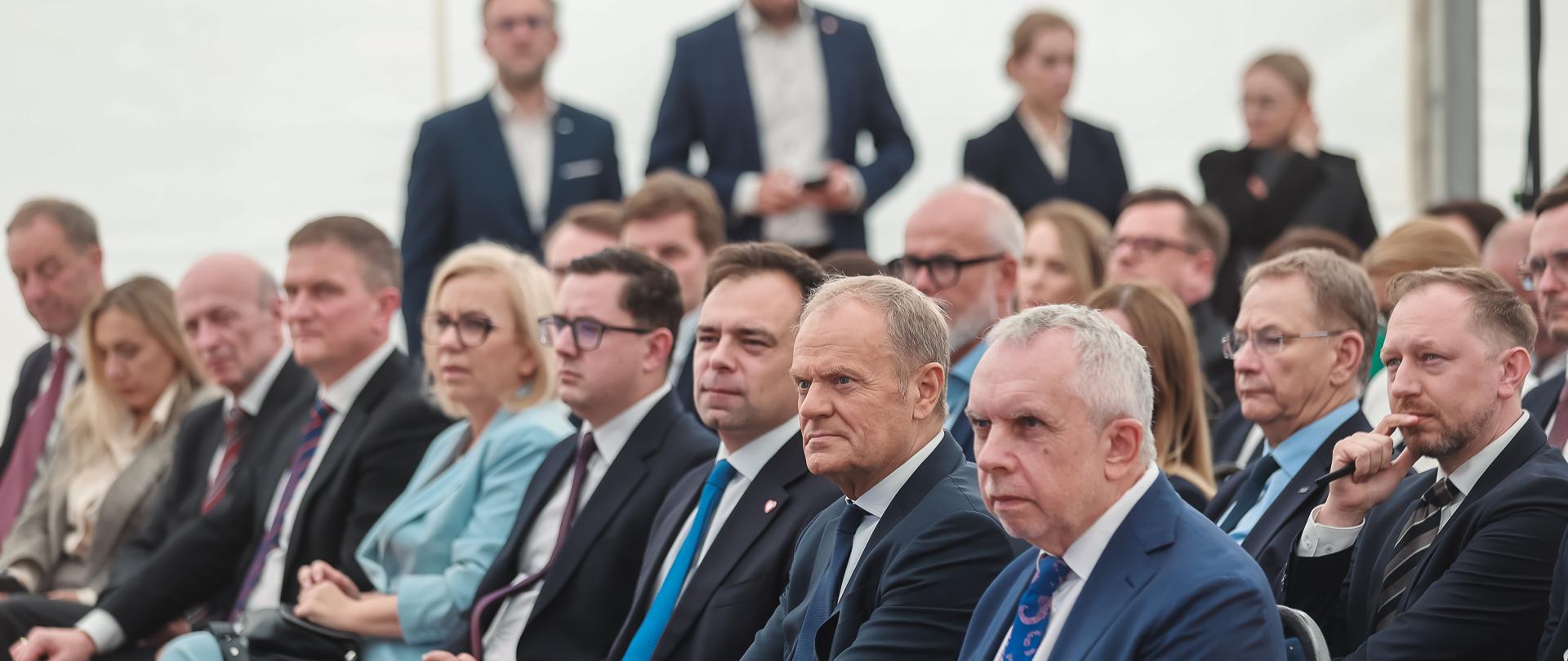 Ministra klimatu i środowiska Paulina Hennig-Kloska podczas uroczystości uruchomienia stacji elektroenergetycznej 400 kV Choczewo - pierwszego w Polsce węzła stworzonego do odbioru energii z offshore. Na zdjęciu widać siedzących ludzi.