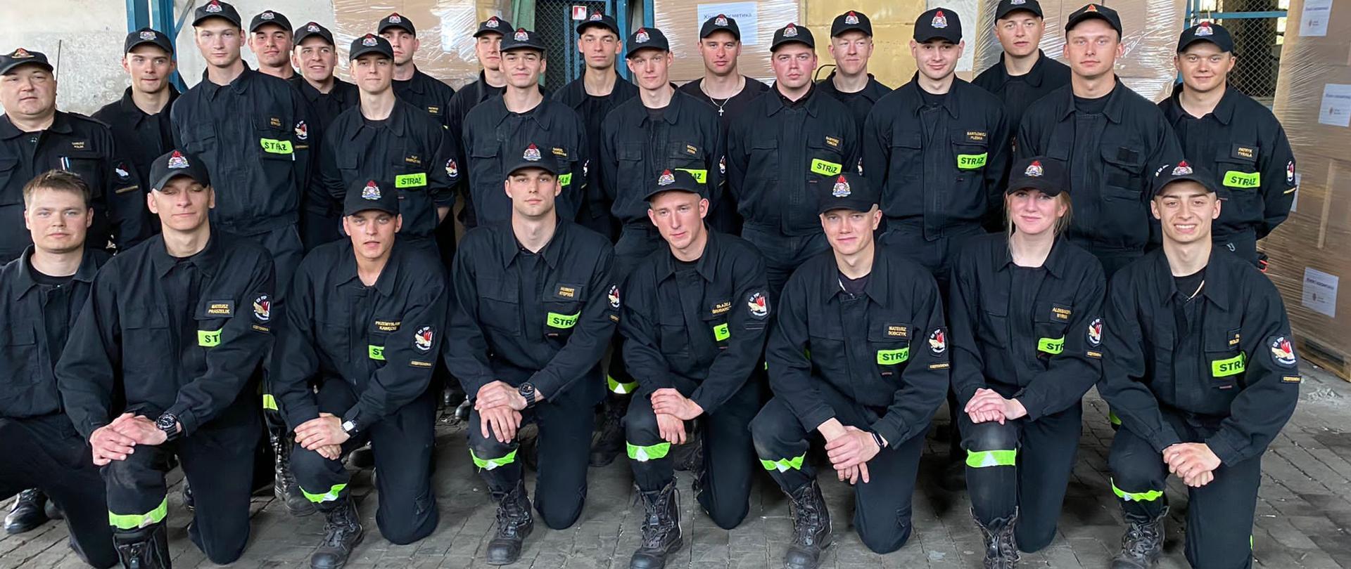 Grupowe zdjęcie plutonu kadetów Centralnej Szkoły PSP (25 osób, w tym jedna kobieta) wraz z dowódcą